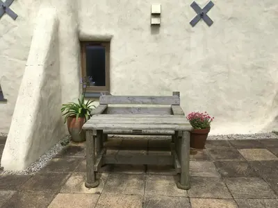 a wooden bench sitting in front of a building at The Corn Store in Porthtowan