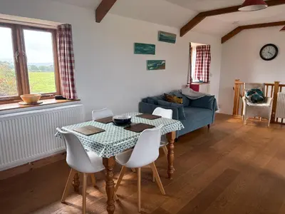 a living room with a table and a couch at The Corn Store in Porthtowan