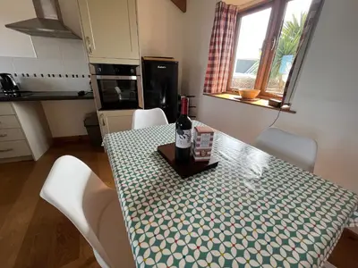 a kitchen with a table with a bottle of wine on it at The Corn Store in Porthtowan