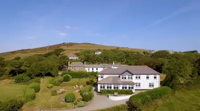 an aerial view of a large white house on a hill at Beacon Country House B & B & Luxury Shepherd Huts in St. Agnes