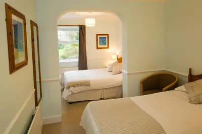 a hotel room with two beds and a window at Beacon Country House B & B & Luxury Shepherd Huts in St. Agnes