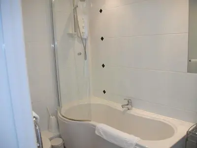 a white bathroom with a tub and a shower at Beacon Country House B & B & Luxury Shepherd Huts in St. Agnes