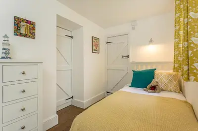a bedroom with a bed with a teddy bear on it at Fal River Cottage in Truro