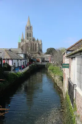 a river in a town with a cathedral in the background at Fal River Cottage in Truro