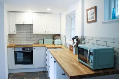 a kitchen with a counter with a microwave on it at Fal River Cottage in Truro