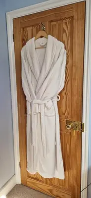 a robe hanging on a door in a bathroom at Sycamore Farm in Launceston