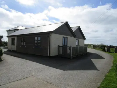 a small house with a gambrel roof on a driveway at The Byre in Porthtowan