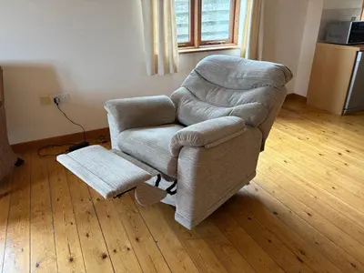 a living room with a chair and a coffee table at The Byre in Porthtowan