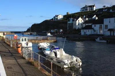 a group of boats docked at a dock in the water at Inner Harbour Cottage in Portreath