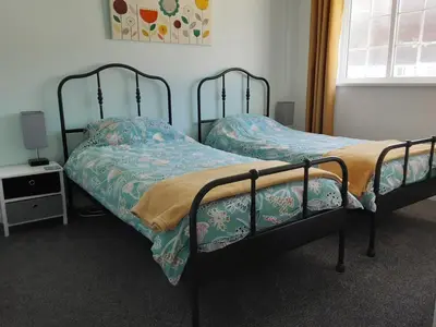 two twin beds in a room with a window at Inner Harbour Cottage in Portreath