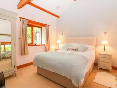 a bedroom with a large white bed and a window at The Wagon House in Launceston