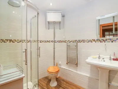 a bathroom with a toilet and a shower and a sink at The Wagon House in Launceston