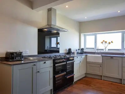 a large kitchen with a stove and a sink at Rocky Close in St Ives