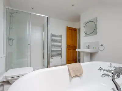 a bathroom with a tub and a shower and a sink at Rocky Close in St Ives