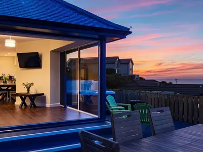 a house with a deck with a view of the ocean at Rocky Close in St Ives