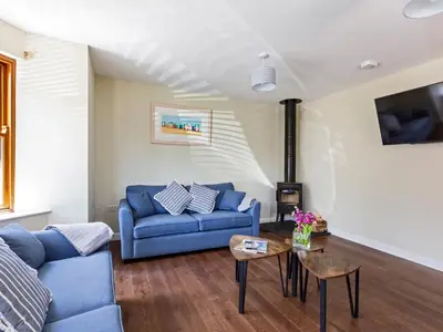a living room with a blue couch and a table at Rocky Close in St Ives