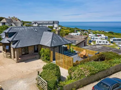 an aerial view of a house with the ocean at Rocky Close in St Ives