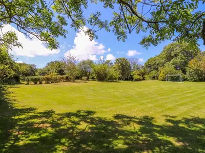 a large grassy field with a soccer ball at Sunbury Barn in St. Agnes