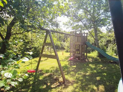 a playground in a yard with a swing at Sunbury Barn in St. Agnes