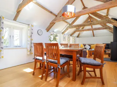 a dining room with a wooden table and chairs at Sunbury Barn in St. Agnes