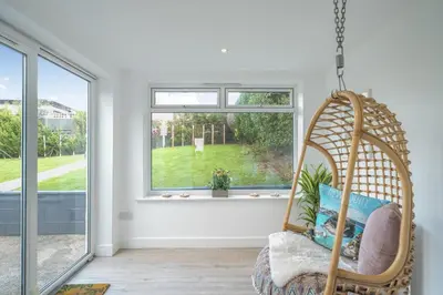 a swinging chair in a room with a window at Chi An Mor in Newquay