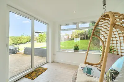 a living room with a large window and a chair at Chi An Mor in Newquay