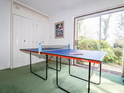 a ping pong table in a room with a window at Trevow in Camborne