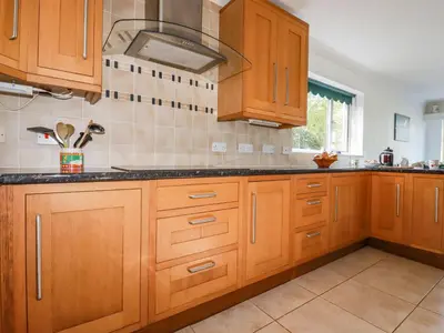 a kitchen with wooden cabinets and a stove at Trevow in Camborne