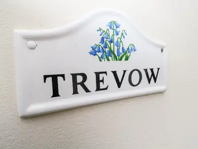 a sign on a wall with blue flowers at Trevow in Camborne