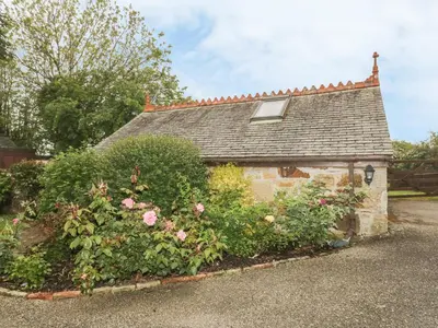 a stone house with flowers in front of it at Little Prickle in Newquay
