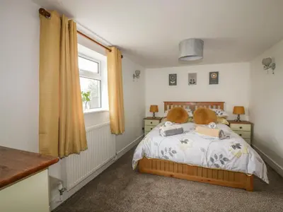 a bedroom with a bed with a teddy bear on it at Little Prickle in Newquay