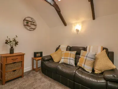 a living room with a leather couch and a table at Little Prickle in Newquay
