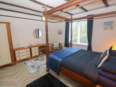 a bedroom with a bed and a desk and a window at Lighthouse in Penzance