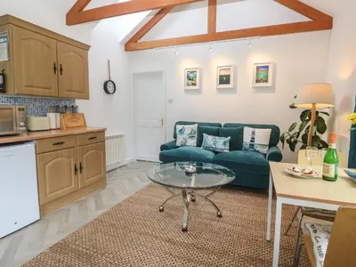 a living room with a blue couch and a table at Lighthouse in Penzance