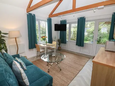 a living room with a blue couch and a table at Lighthouse in Penzance