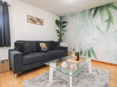 a living room with a couch and a glass table at Palm Lodge in Penzance