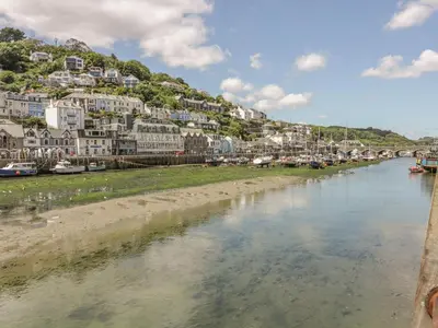a river in a town with houses on a hill at Lowena Cottage in Looe