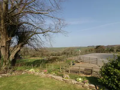 a group of benches in a field with a tree at The Coach House in Saint Columb Major