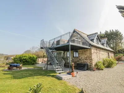 a house with a spiral staircase on the side of it at The Coach House in Saint Columb Major