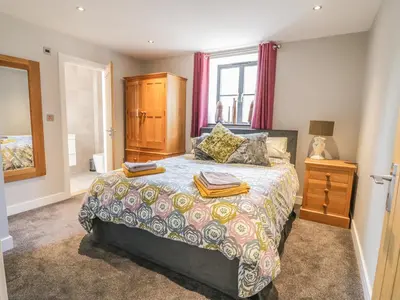 a bedroom with a large bed and a window at The Coach House in Saint Columb Major