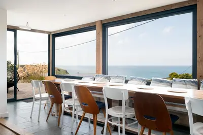 a dining room with a table and chairs at Blue Bay Beach House in Newquay