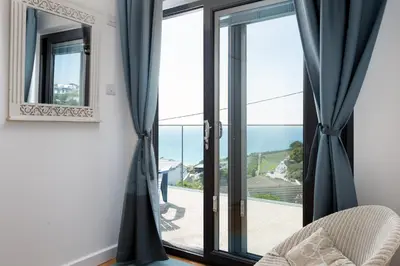 a room with a window with a view of the ocean at Blue Bay Beach House in Newquay