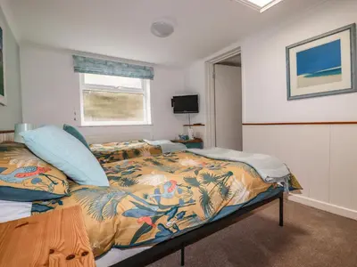 a bedroom with a bed with a colorful comforter at Blue Bay Beach House in Newquay