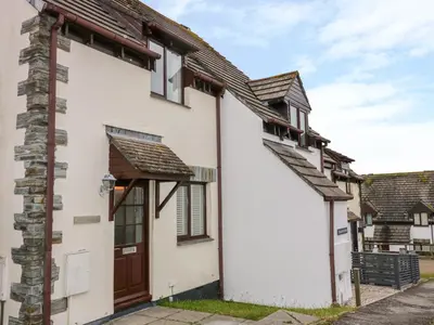 a house with a wooden door and a stairway at Sarah's Cottage in Padstow