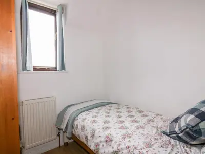 a bedroom with a bed and a window at Sarah's Cottage in Padstow