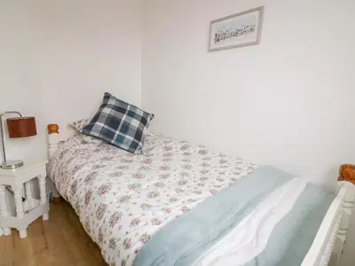 a bedroom with a bed with a pillow on it at Sarah's Cottage in Padstow