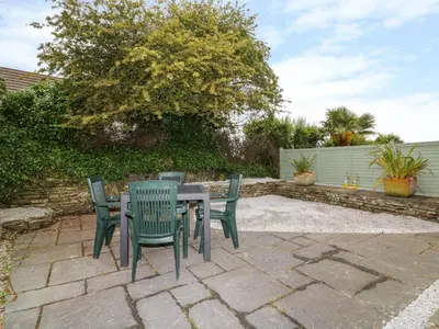 a patio with a table and four chairs at Sarah's Cottage in Padstow