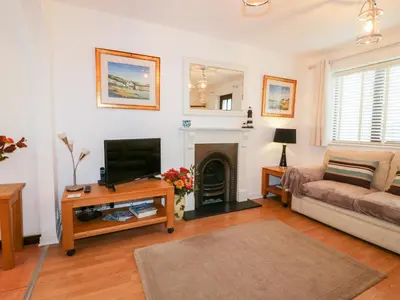 a living room with a couch and a fireplace at Sarah's Cottage in Padstow
