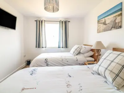 a bedroom with two beds and a tv at Sea Dreams in Marazion