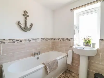 a bathroom with a bath tub and a sink at Sea Dreams in Marazion